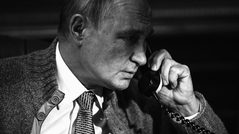 A black-and-white photo of Vladimir Putin holding a phone to his left ear