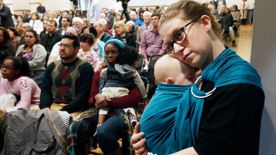 A woman holds her baby at a Pittsburgh memorial service at Temple Emanuel in Roanoke, Virginia.