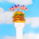 Double-decker chicken sandwich studded with American flags on a white pedestal