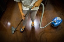 A person vacuums a hardwood floor.