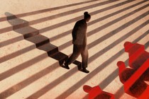 An illustration of a woman in business attire walking down steps, similar to ones at a courthouse. Three red figures wait at the bottom of the steps.