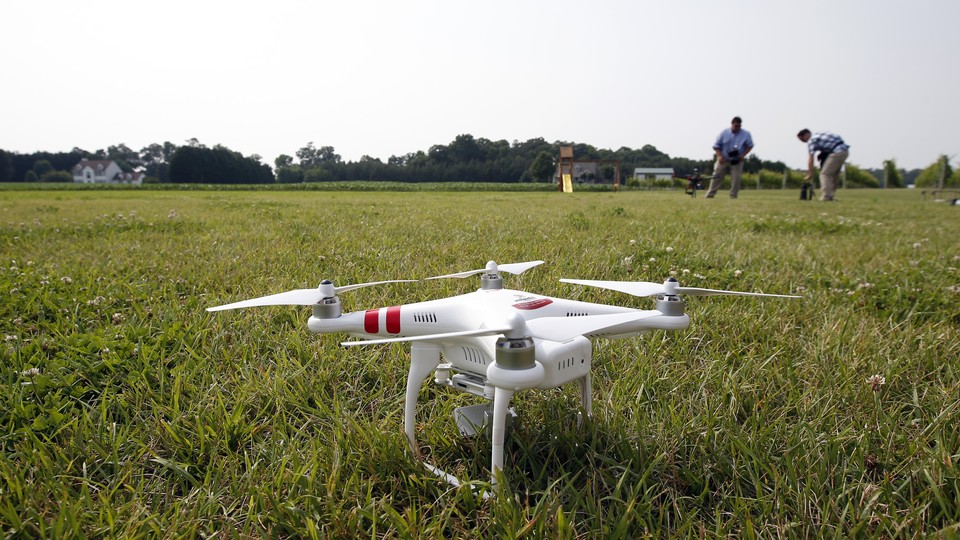 A DJI Phantom 2 drone sits on grass.