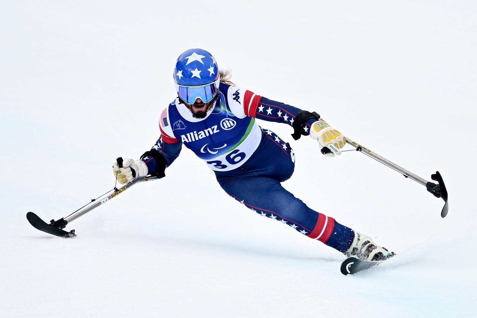 A para-alpine skier using outrigger skis leans and makes a tight turn.