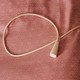 A hospital-assistance pull-cord rests on a pink bedspread on a hospital bed.