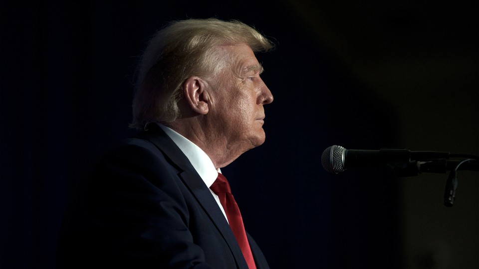 Side picture of Trump before a microphone