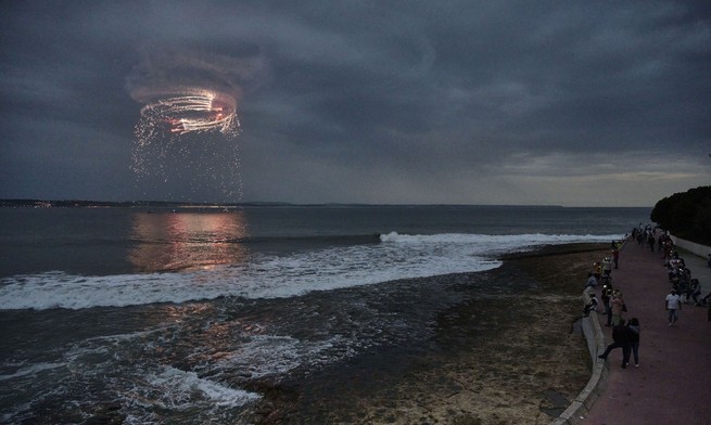 feux d'artifice sur l'océan pendant que les spectateurs regardent