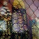 A skyline seen through a chain-link fence
