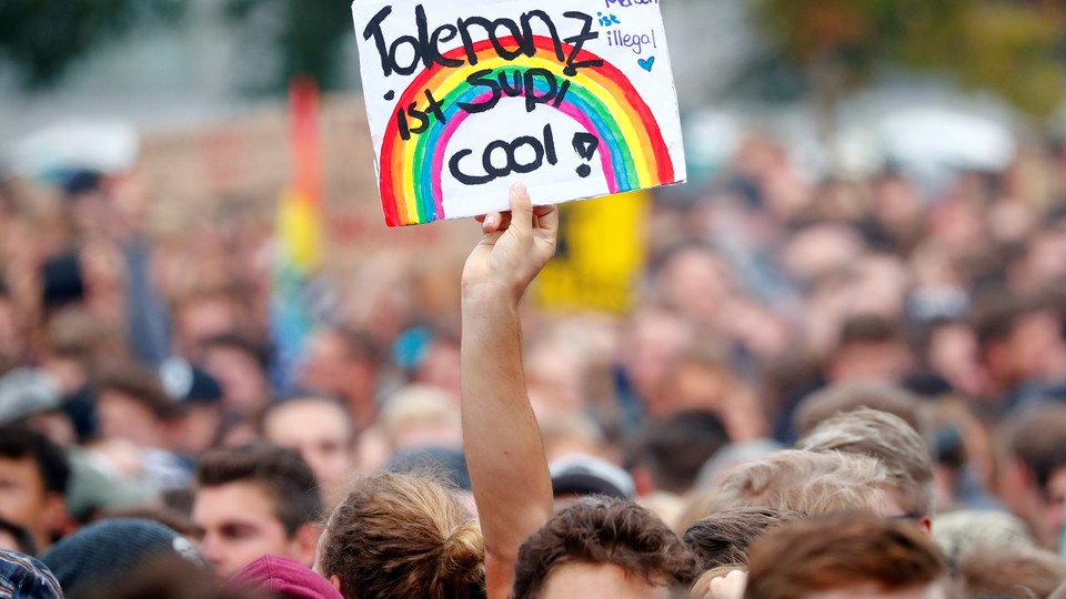 An attendee at an anti-racism concert in Chemnitz last month holds a poster that says "Tolerance is super cool."