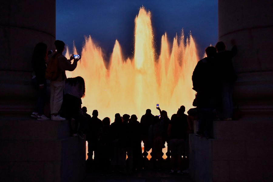 People gather to watch an illuminated water fountain.