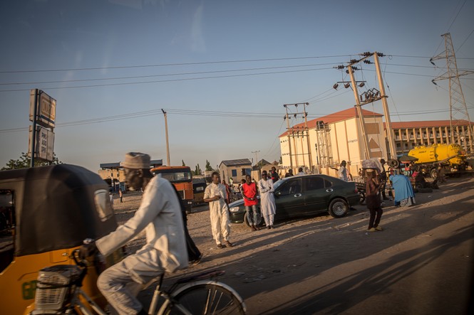 Residents walk under power lines in Maiduguri, the capital of Borno State. Islamic militant group Boko Haram, and more recently a faction called ISWAP, have been waging an insurgency in northeast Nigeria for more than a decade. 