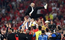 A man is tossed into the air by a celebrating soccer team.
