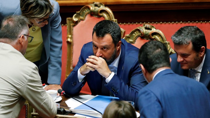 Matteo Salvini sits at a desk as he meets with other Italian lawmakers.