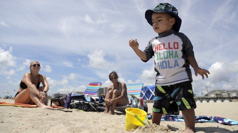 A toddler plays in the sand at the beach.