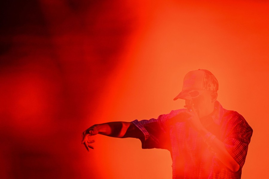 A performer onstage bathed in reddish light.