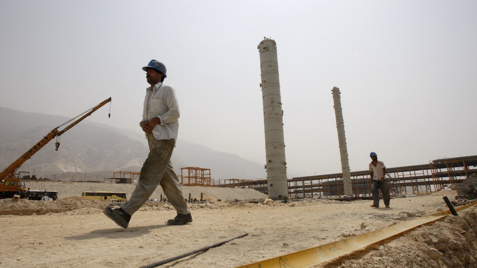 Iranian workers walk in a construction site which is part of South Pars gas field, on the northern coast of Persian Gulf, Iran.