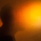 A silhouette with the face blurred out by a bright orange light