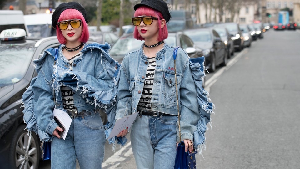 Two women with pink hair dressed in matching denim outfits