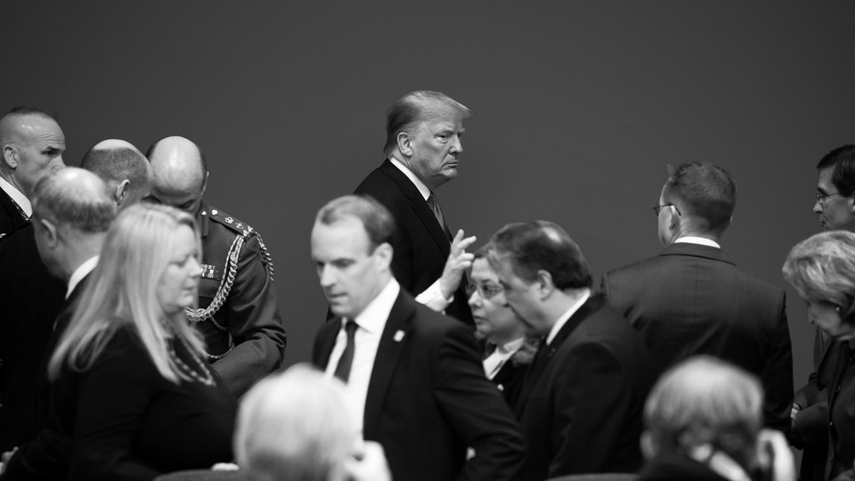 Black-and-white photo of Donald Trump in a roomful of people