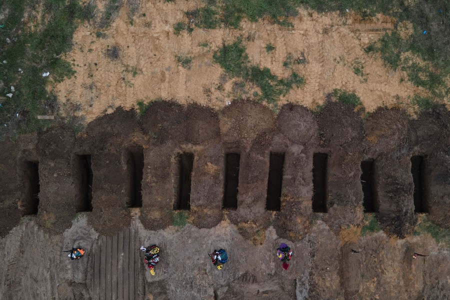An aerial view of freshly dug graves in a cemetery.