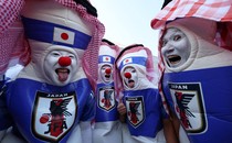A group of four soccer fans wear makeup and costumes to cheer for Team Japan.