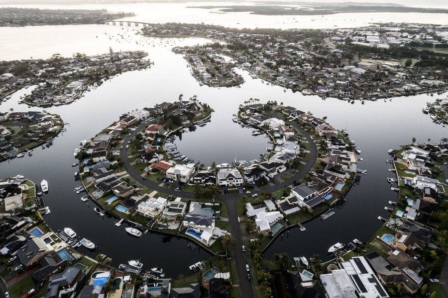 An aerial view of waterfront homes in a neighborhood along a bay
