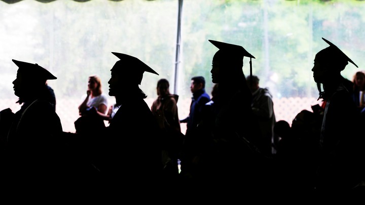 Female college graduates stand in a line.