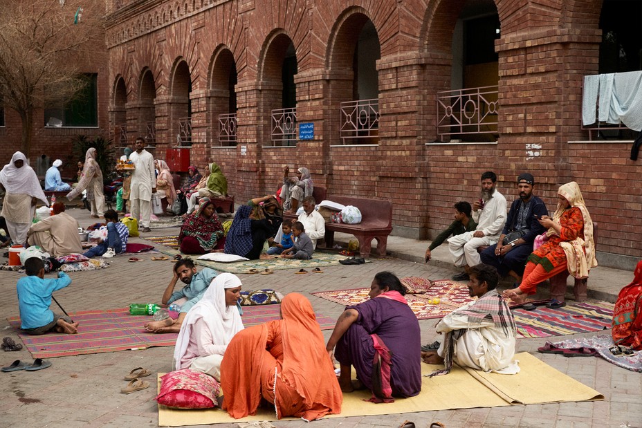 Patients and relatives waiting outside Mayo Hospital in the heat