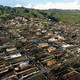 An aerial view shows empty lots and new homes under construction on a California hillside.