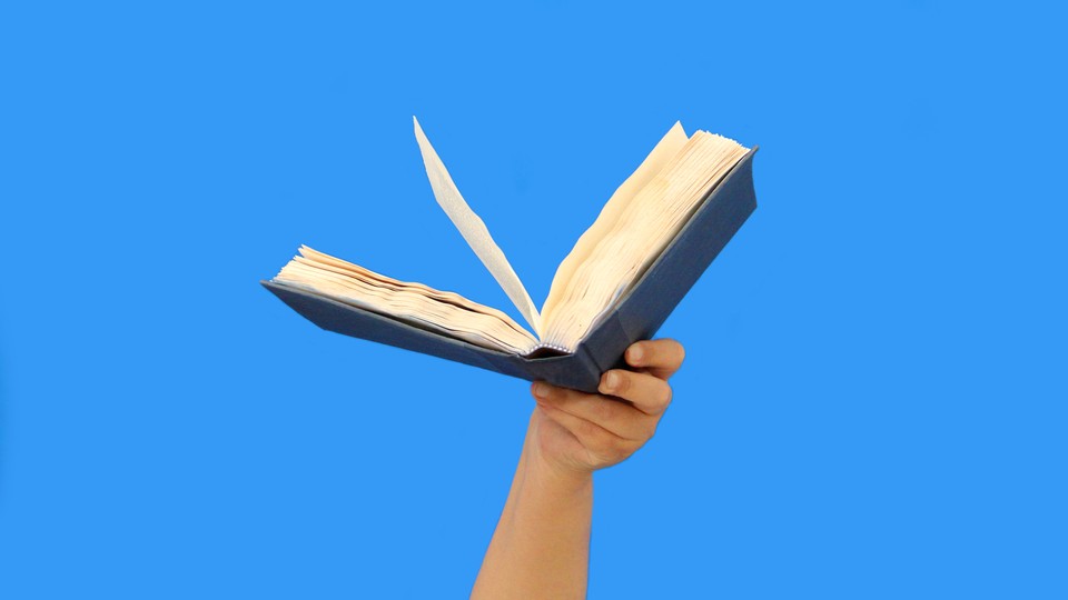 A photo of a hand holding a book