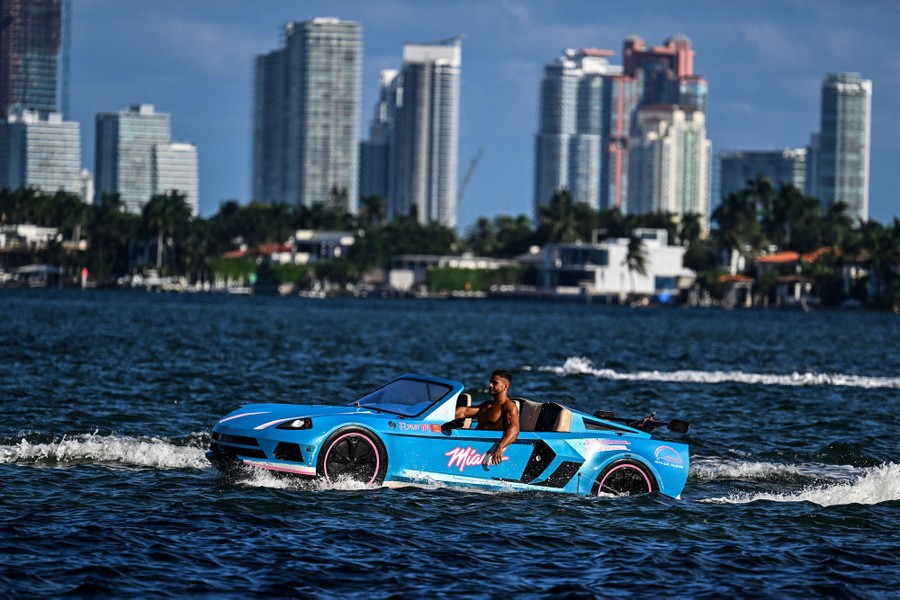 A man drives a modified boat shaped to look like a sports car.
