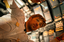 Color film still from “Project Hail Mary,” showing Ryan Gosling floating sideways in a space vehicle.