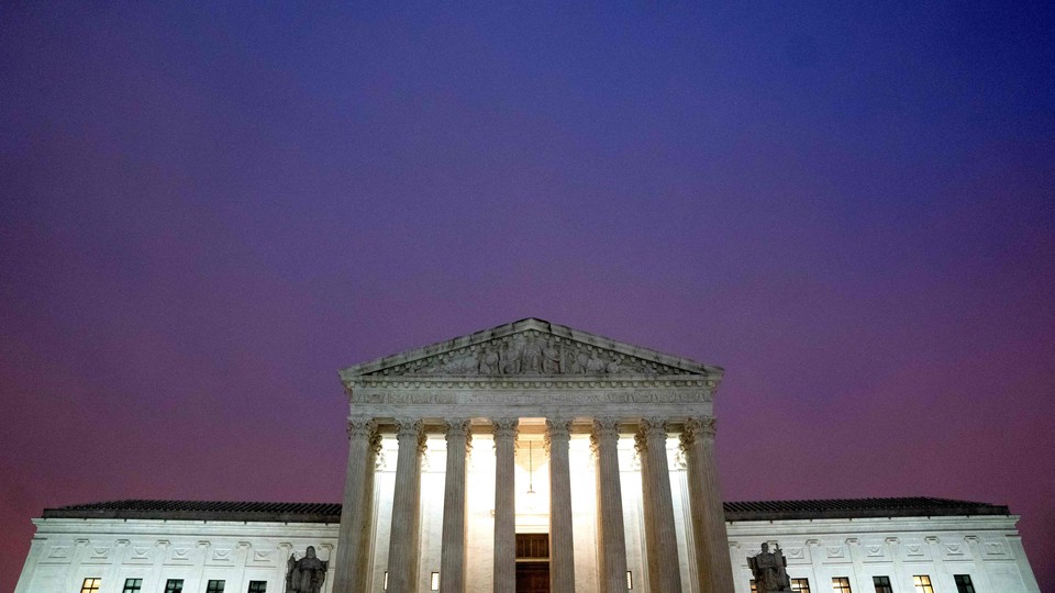 The Supreme Court building in front of a purplish-blue sky