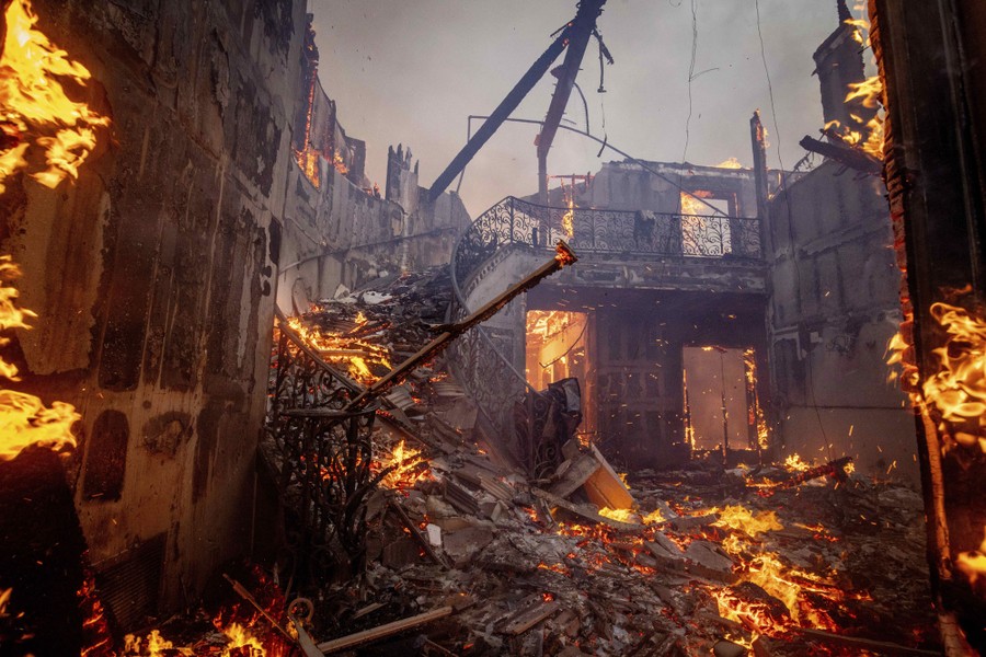 A spiral staircase amid the wreckage of a burned house.