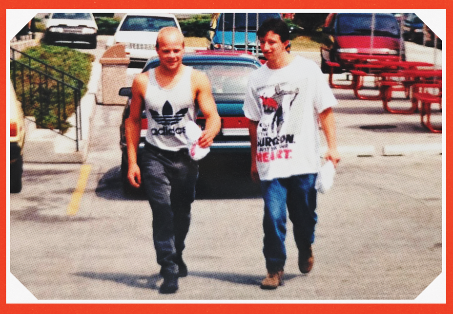 candid photo of two men walking in parking lot