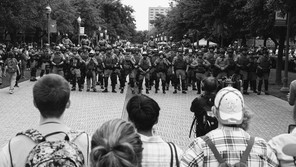 A photo of student protesters facing off against riot police.