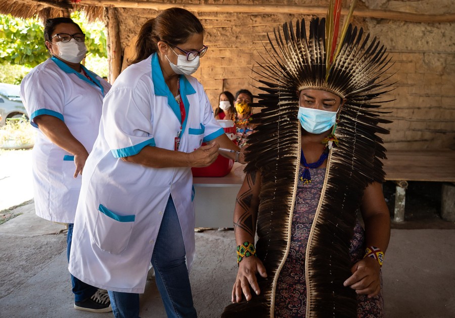 A person in traditional dress receives a vaccination.