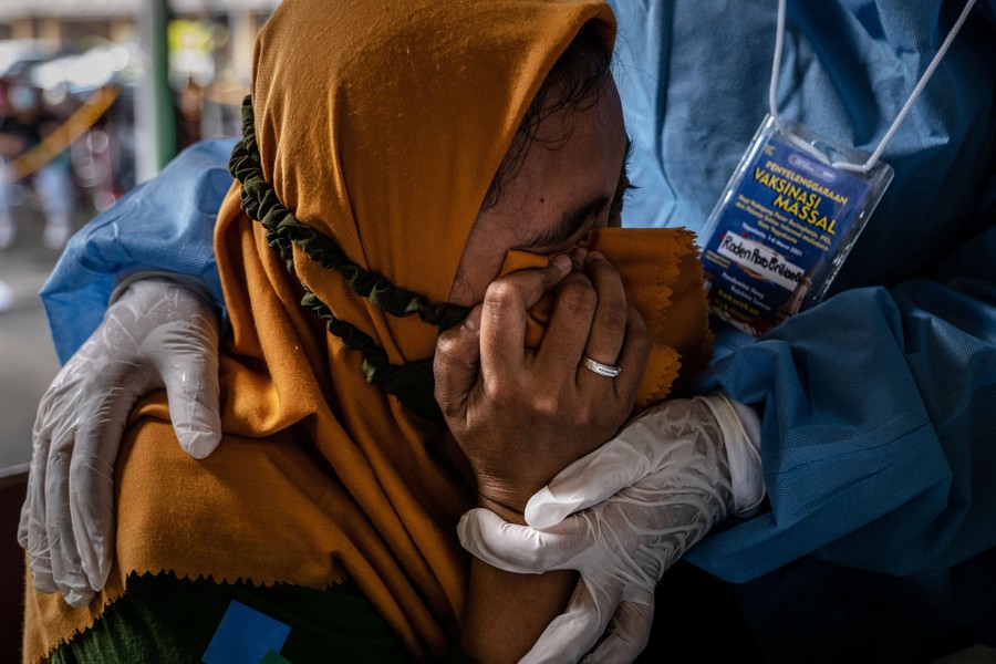 A woman reacts emotionally after getting her vaccine shot.