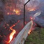 The lava flow from the Kilauea volcano moves over a fence on private property near the village of Pahoa, Hawaii, in 2014. 