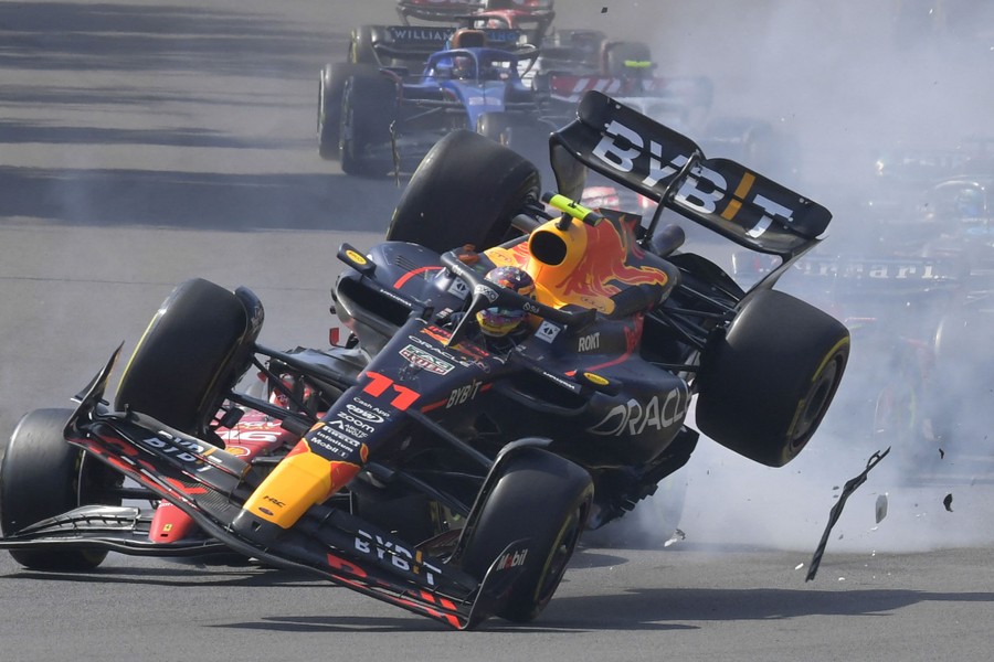 A Formula One race car seen mid-crash, with only its front left tire touching the ground.
