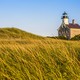 A granite lighthouse surrounded by grass, on Rhode Island's Block Island