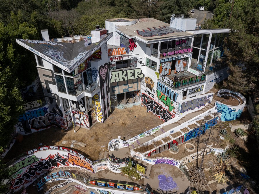 An aerial view of a mansion covered with graffiti