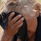 A person mopping sweat off their forehead with a blue towel