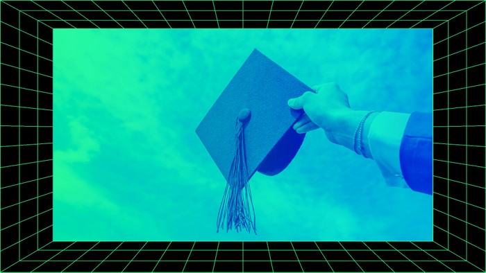 A hand holds a graduation cap