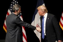 Falwell, left, smiles as he shakes hands with Trump, who appears to be mid-sentence.