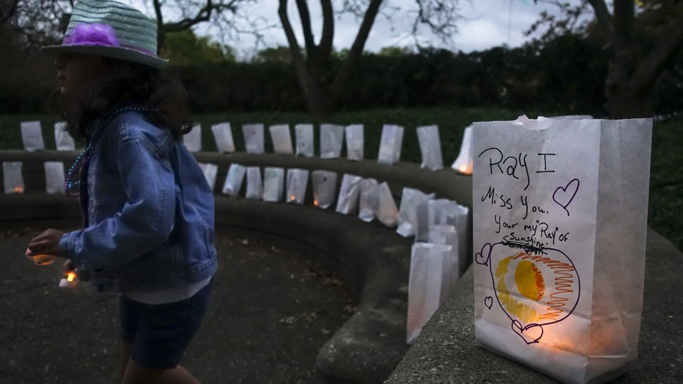 A woman lights a candle for someone who died by suicide.