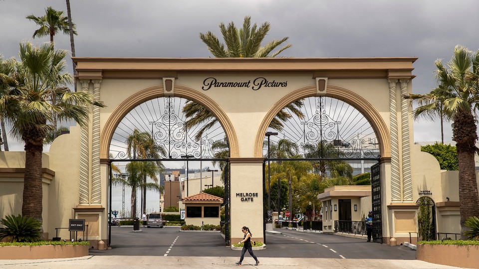 A pedestrian walks past the entrance to Paramount Pictures on Melrose Avenue in Los Angeles.