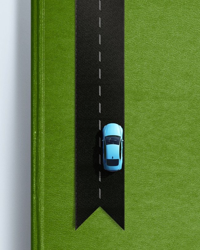 A car driving on a bookmark made to look like a road