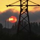 Power lines against a smoky red sky