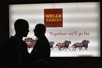 Patrons stand outside a Wells Fargo bank