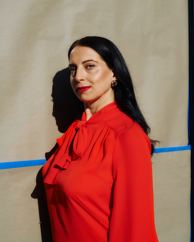 A photo of a woman with dark hair, bright-red lipstick, and a red blouse